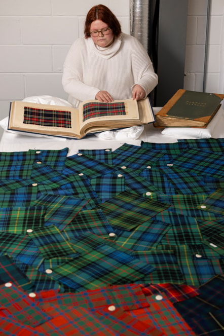 A University of Glasgow students examines the tartan samples. Photo © Duncan McGlynn (2)