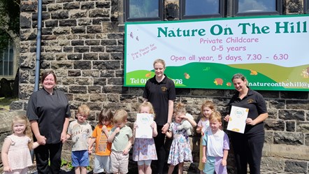 Staff and youngsters celebrate at Nature On The Hill
