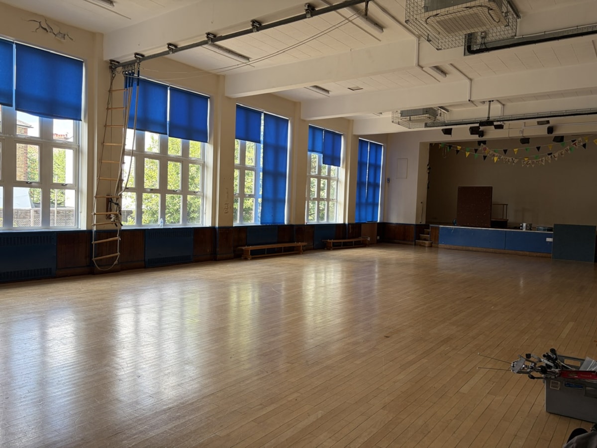An empty, sunlit school hall with polished light-wood floring in the closed Oldhill Community School