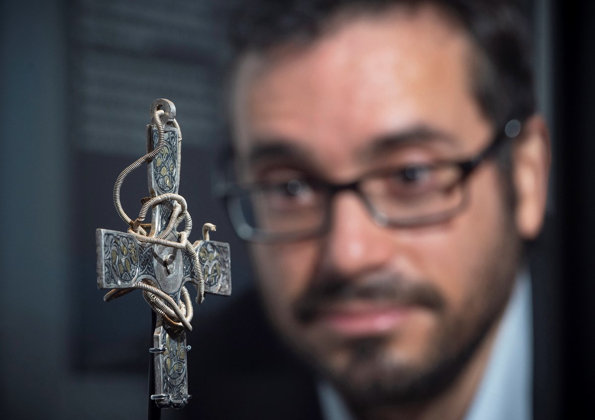 Galloway Hoard Researcher Dr Adrian Maldonado examines the pectoral cross from The Galloway Hoard credit Neil Hanna