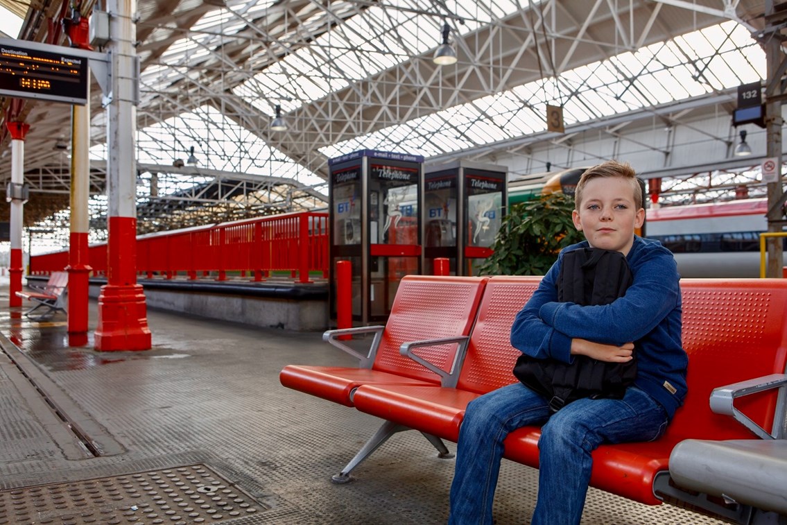 Railway Children Sleepout: Vulnerable young boy (model) sat alone in station