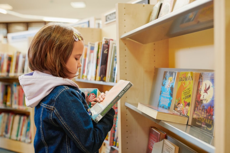 child looking at library books
