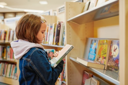 child looking at library books