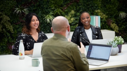 Colleagues at table with green background