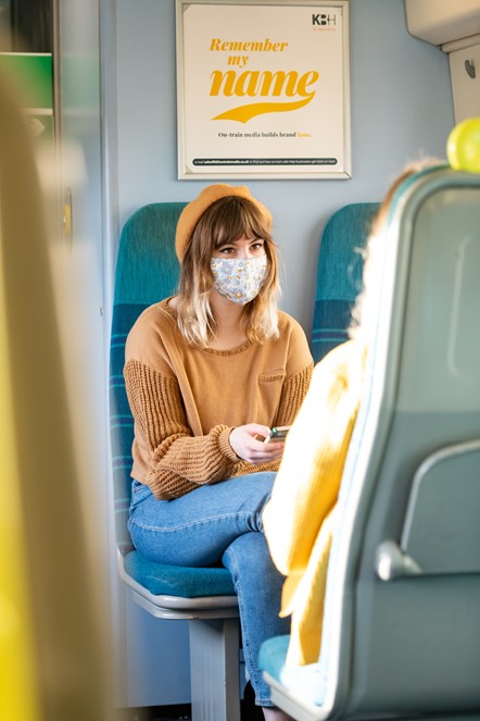 Female passenger on train with face covering (Vertical)