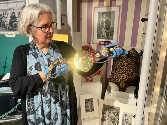 In the Picture: Curator Kitty Ross with a leotard and belt once worn by the city’s own female wrestler Sue Brittain, later known to opponents as Lady Satan.
Outside the ropes the pioneering grappler’s real name was Marjorie Farrar. She lived in Pudsey and throughout her career, fought a series of legal battles to be allowed to compete, including using equal opportunities legislation against the then Greater London Council during a two-day court hearing in 1979.