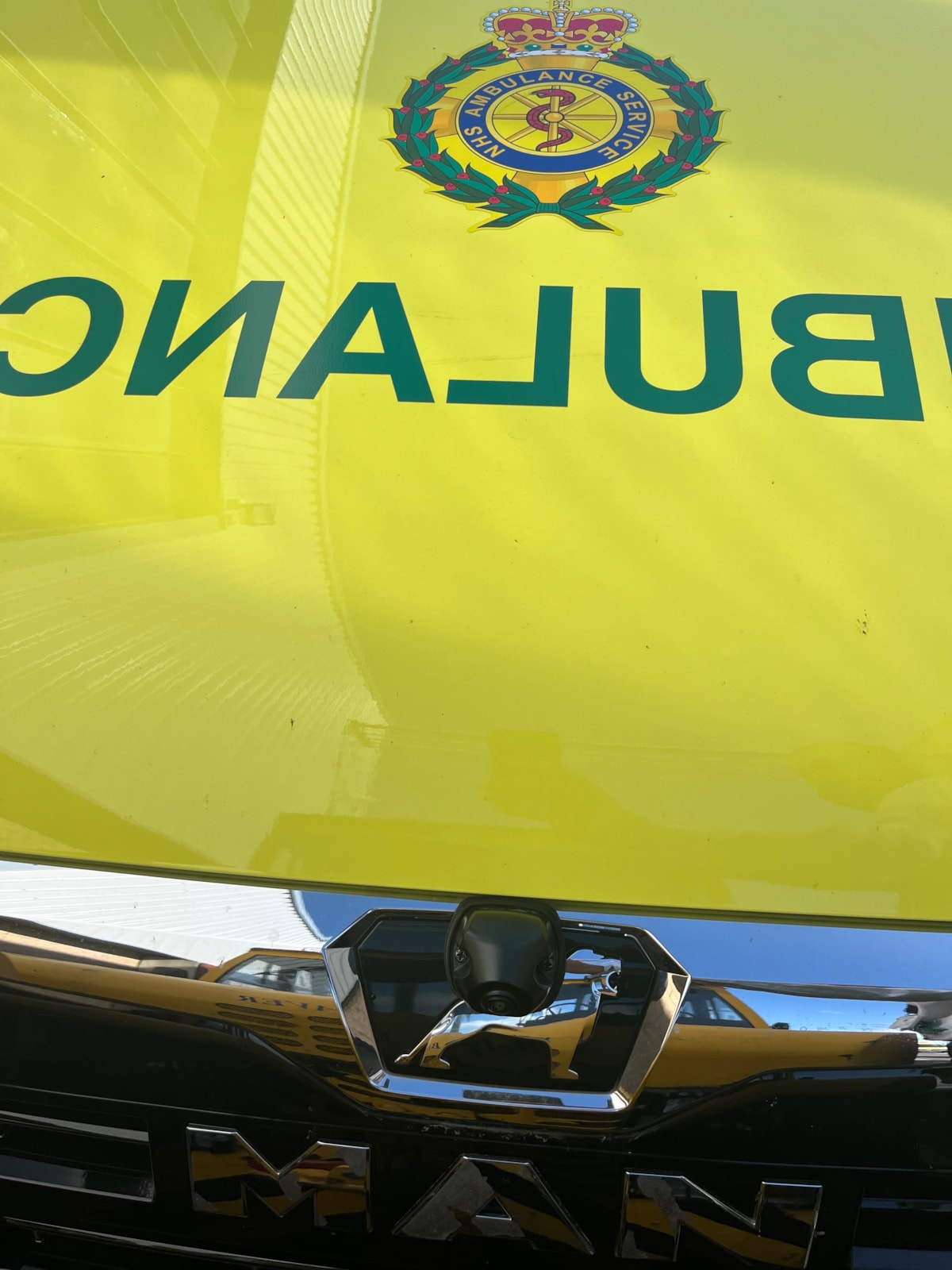 Lower front of ambulance with NEAS badge and vehicle make badge