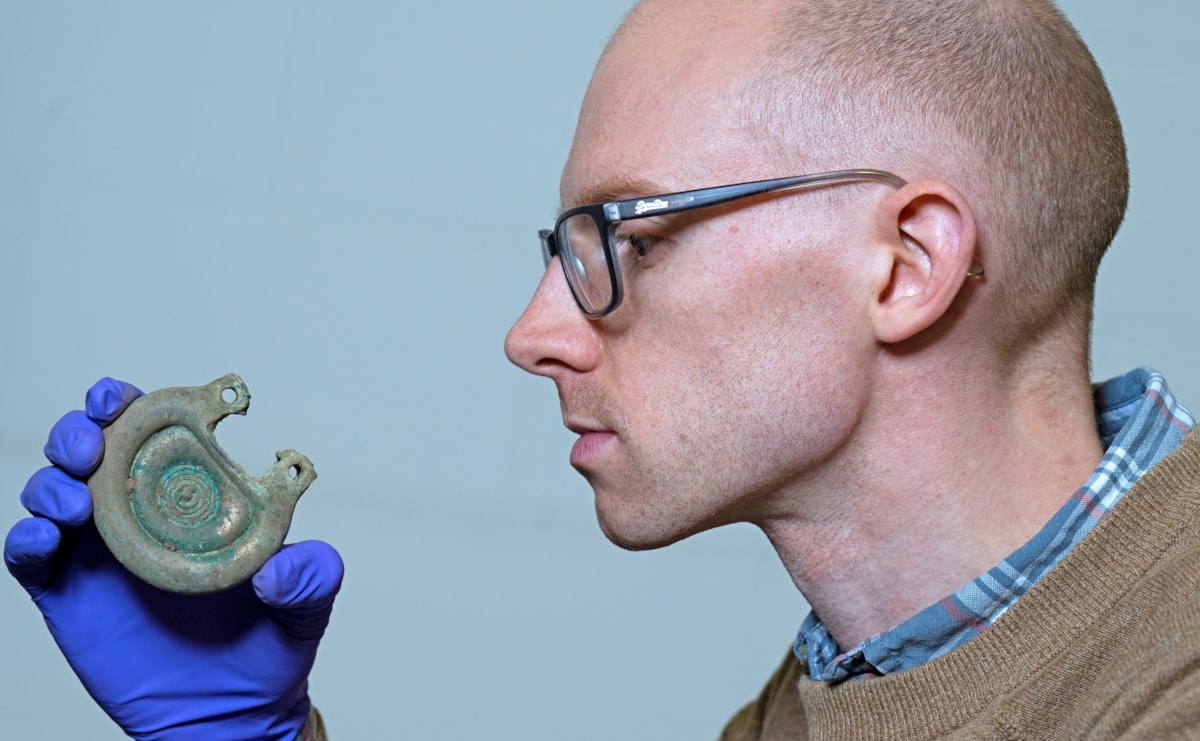 05. Curator Dr Matthew Knight examining a bronze object from the Peebles Hoard. Photo © Neil Hanna