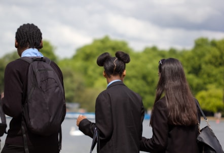three young people walking in school uniforms