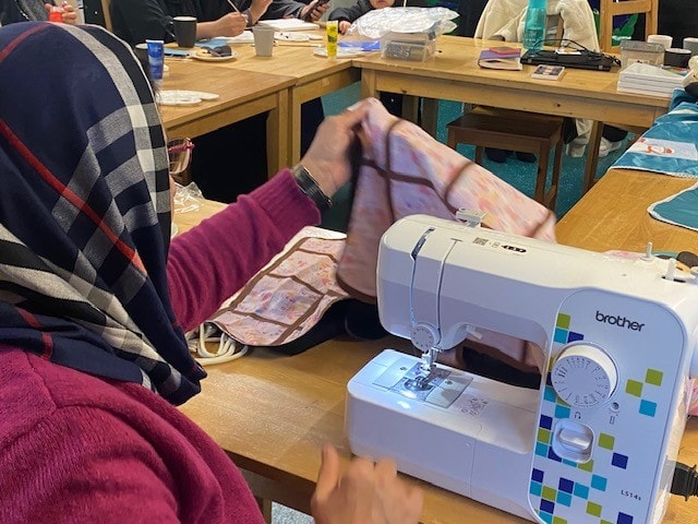 Afghan refugee Aziza sews a pink incubator cover for premature babies at Furness General Hospital