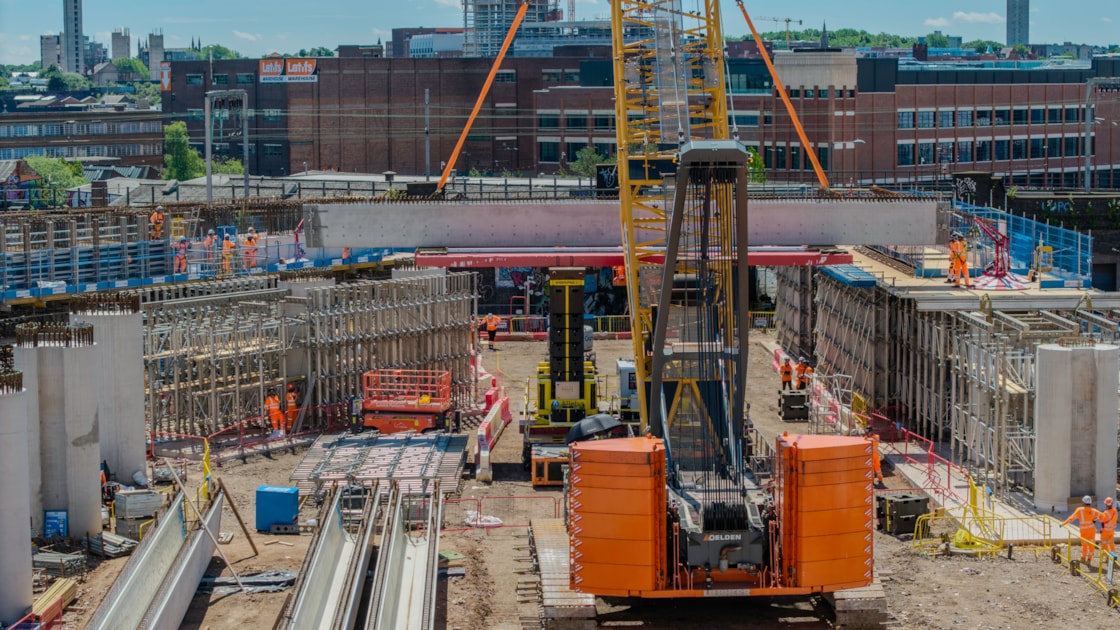 A crawler crane lifting a U-Beam onto an SPMT at Curzon Street June 2026