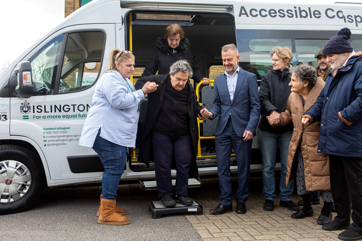 A resident is helped off an Islington Council electric minibus