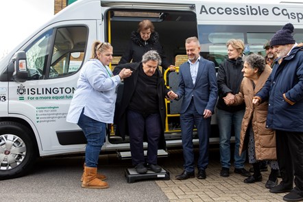 A resident is helped off an Islington Council electric minibus