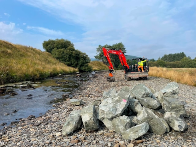 Boulders stacked and ready to be placed in the channel
