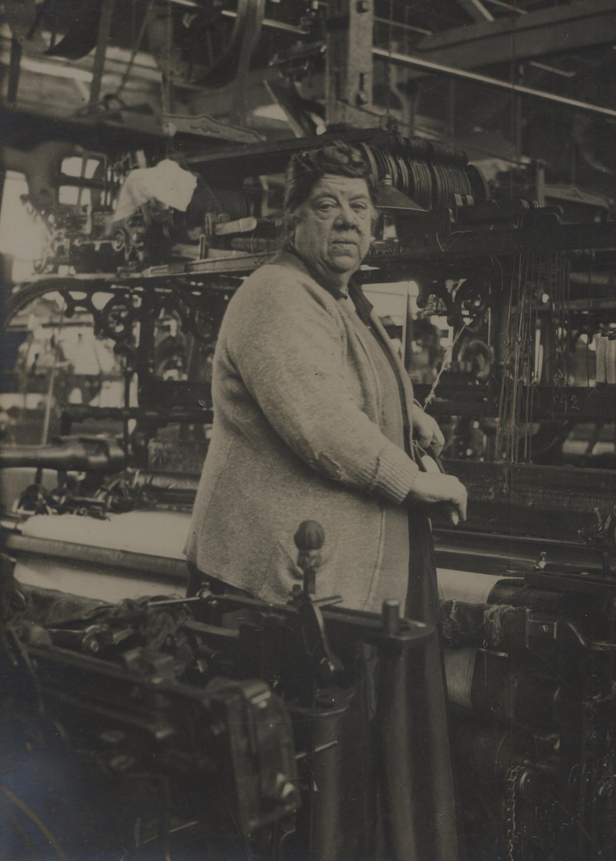 Yorkshire looms: Mrs Hardy, a weaver at W. E. Yates Ltd., Wellington Mills, Bramley to mark the occasion of her 40th year on the same loom from June 1887 until December 1927. Depicts Mrs Hardy's loom and other looms in background.