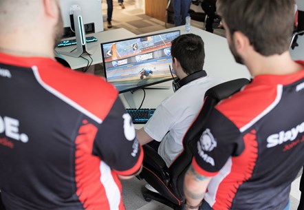 Esports Wales in-game shot with two spectators over sholder - Photo by Esports Wales