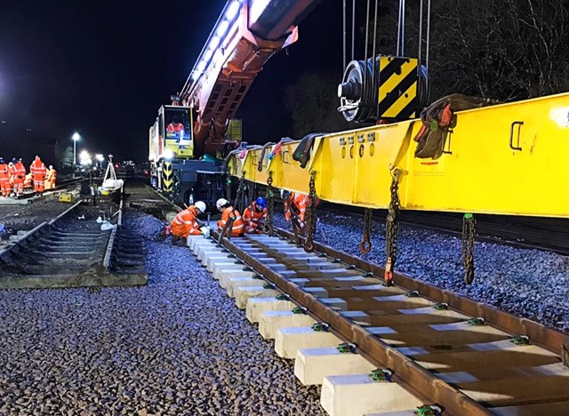Major upgrades to the railway in the north east to result in changes to services in March: Library image of Network Rail engineers positioning section of railway track landscape