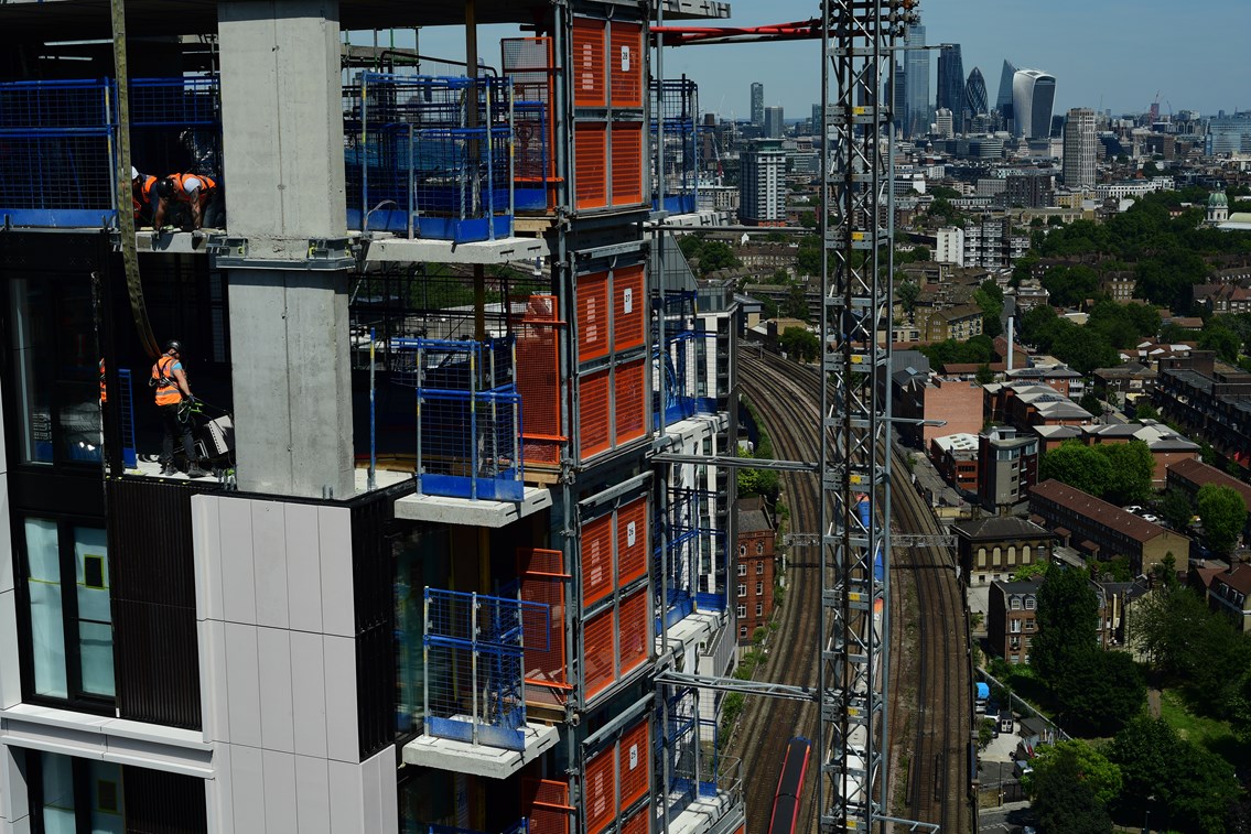 London apartments under construction by the railway - working at height: Open for Business, OfB, Asset Protection and Optimisation, ASPRO, partnership, partner, client, third party, outside party, railway, building, construction, worksite, work, team briefing