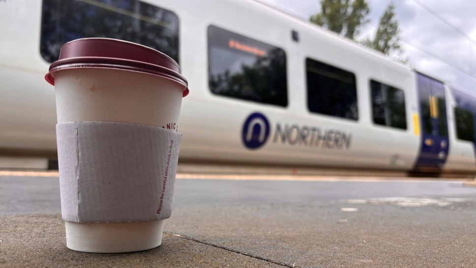 Image shows coffee cup alongside Northern train