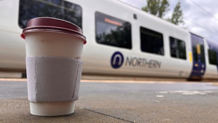 Image shows coffee cup alongside Northern train