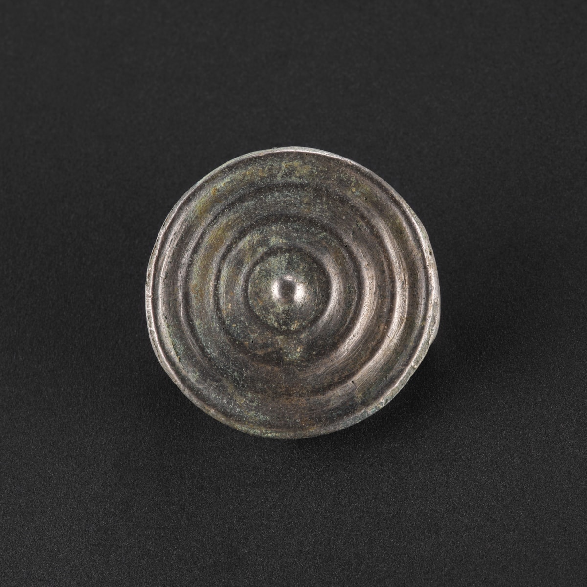 Decorated bronze button from the Peebles Hoard. Photo © National Museums Scotland