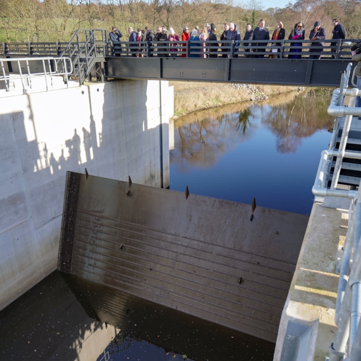 FAS2 storage gate activated: A bridge full of guests looking down at a raised barrier on the River Aire