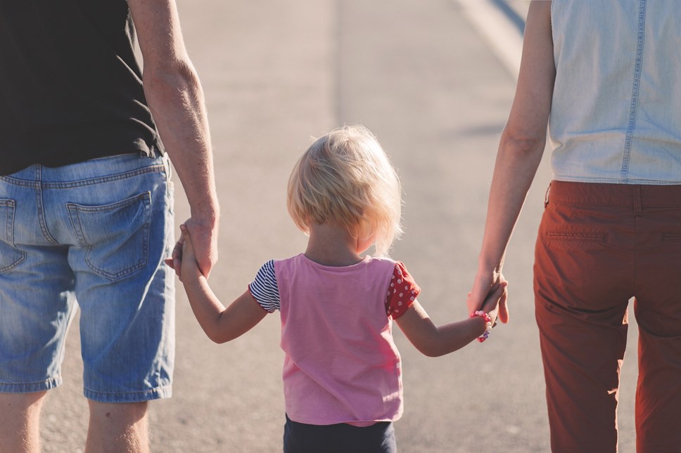 Child holding hands with grown ups