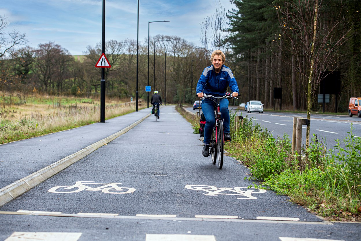 East Leeds Orbital Route lady riding bike on cycle lane.