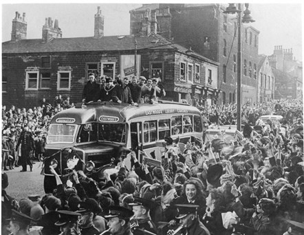 The Burnley players on the Burnley FC. Parade bus, Manchester Road, Burnley arrive home to a resounding welcome from fans after narrowly losing the F.A. Cup Final to Charlton Athletic in April 1947. The old fire station can be spotted in the middle on the right.