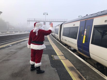 This image shows Father Christmas waving to the Santa Express train