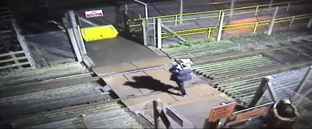 Man runs across level crossing with toddler
