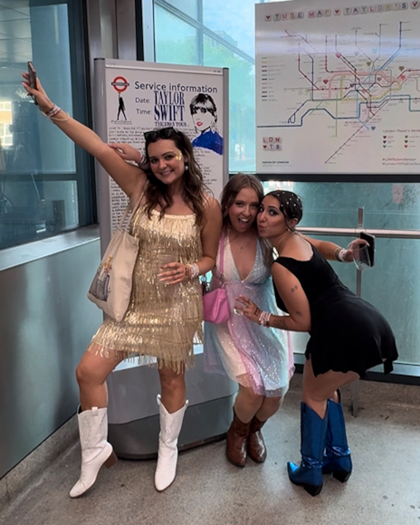 TfL Image - Fans attending Taylor Swift's The Eras Tour pose in front of TfL's Swift-themed Tube map at Wembley Park Tube station