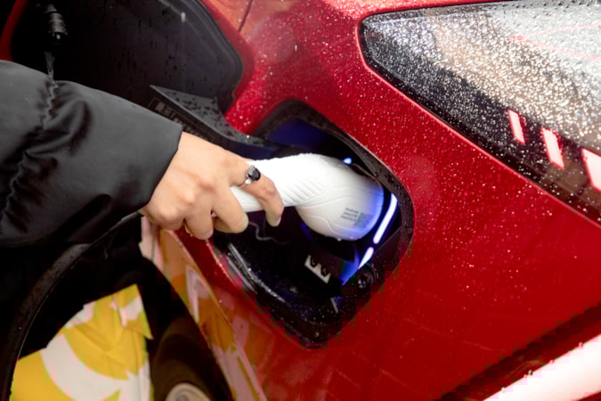 Motability Scheme customers hand charging electric car