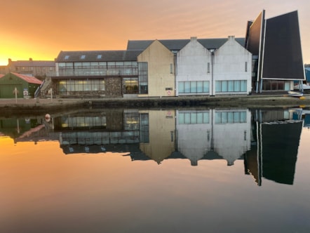A photo of Shetland Museum and Archives that shows the building reflected in the water.