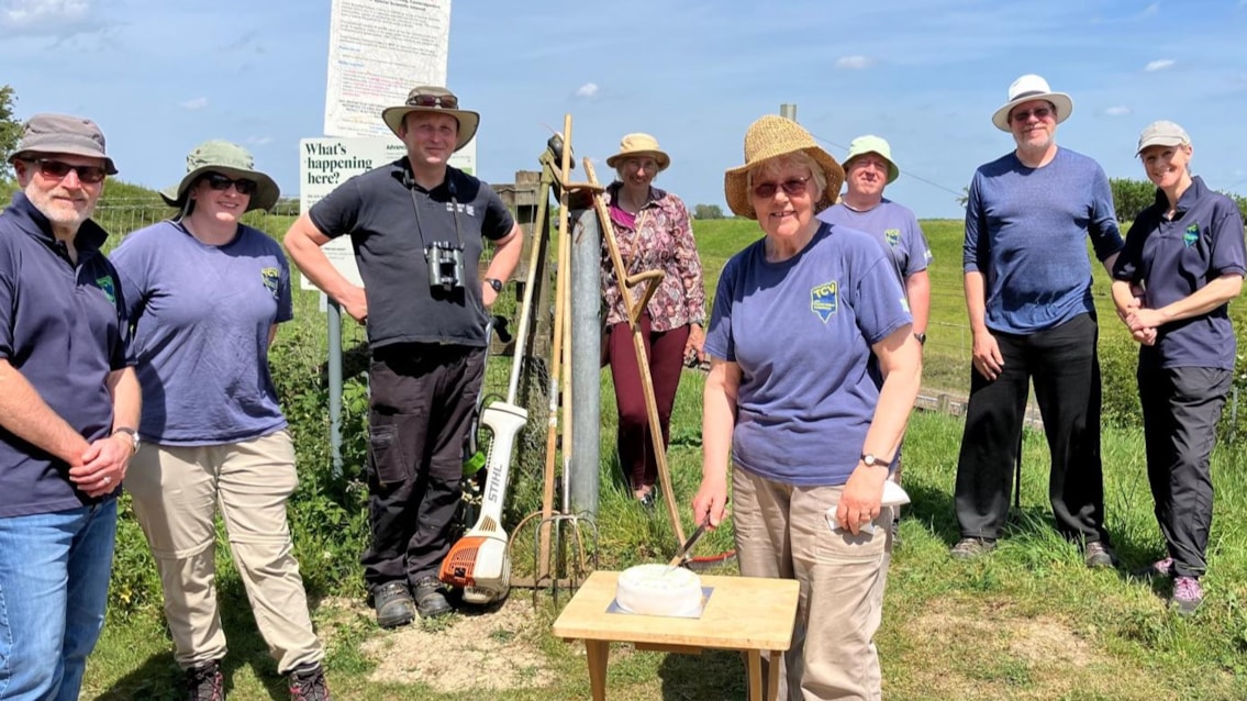 Volunteers celebrate 20 years of transforming wildlife site beside railway: 20 YEARS - Volunteer Hazel Watkins cuts celebration cake