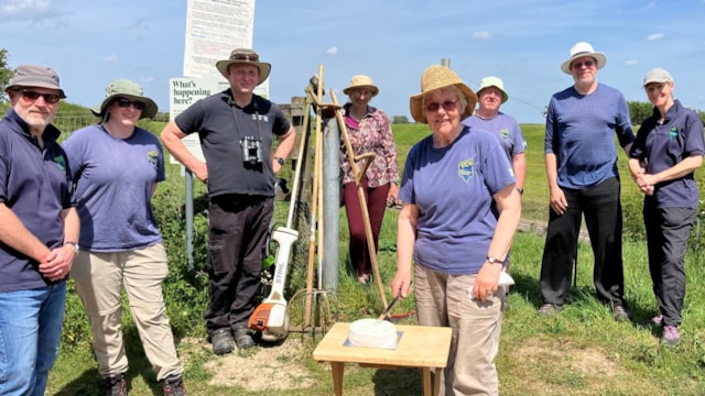 Volunteers celebrate 20 years of transforming wildlife site beside railway: 20 YEARS - Volunteer Hazel Watkins cuts celebration cake