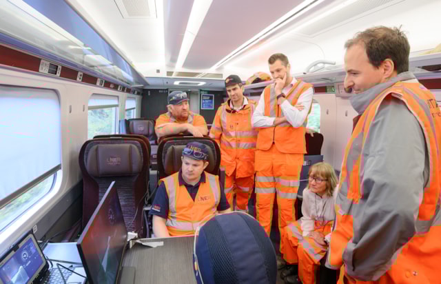 Ed Akers, Linda Wain and project team members viewing livefeed on testing train