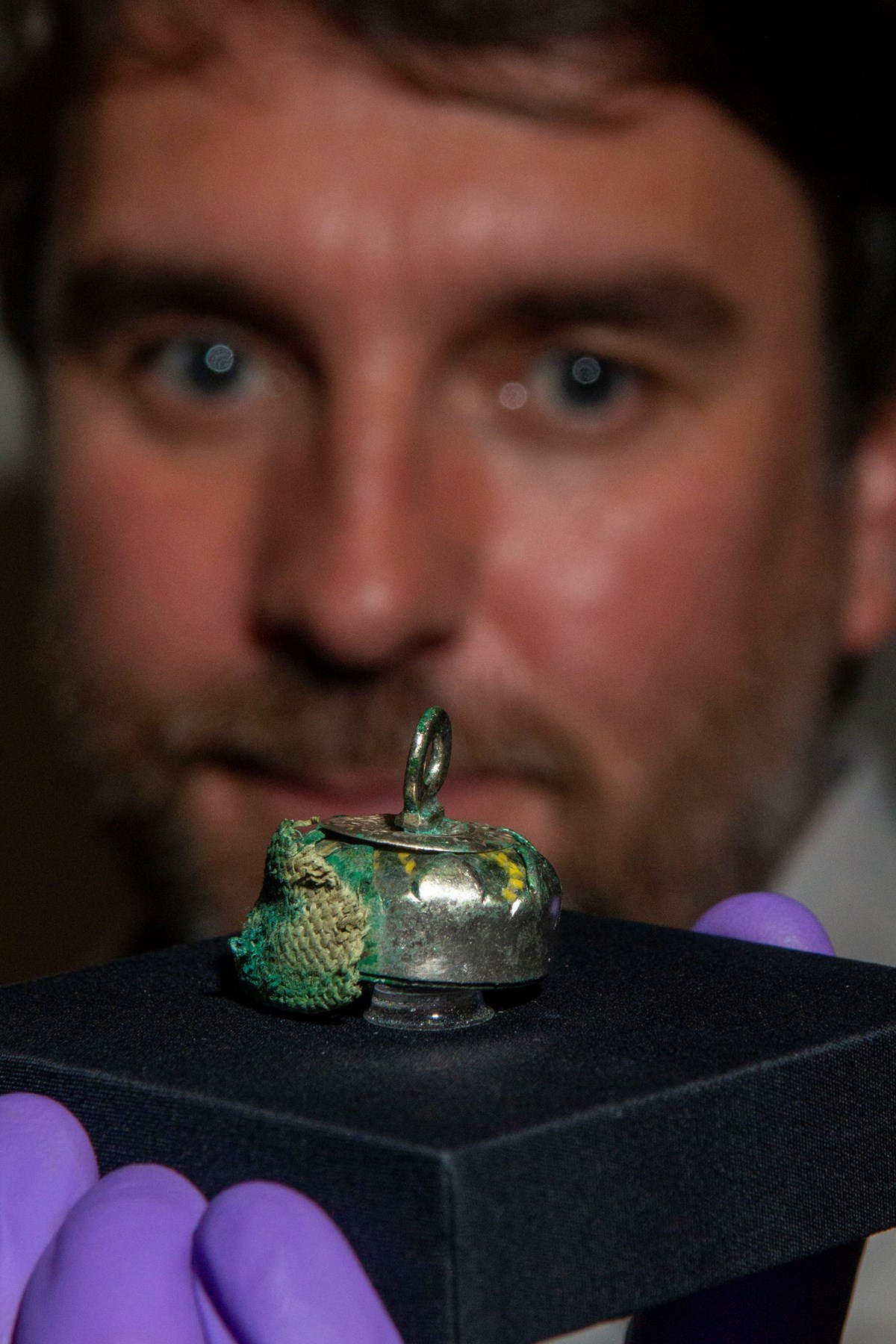 Dr Martin Goldberg and a relic bead pedant with traces of rare textiles from the Galloway Hoard. Photo © Aberdeen City Council (1)