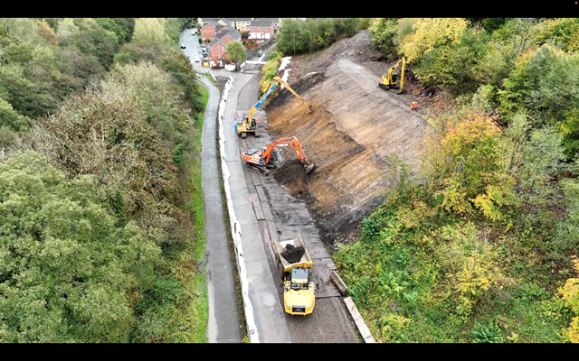 Diggers smoothing embankment
