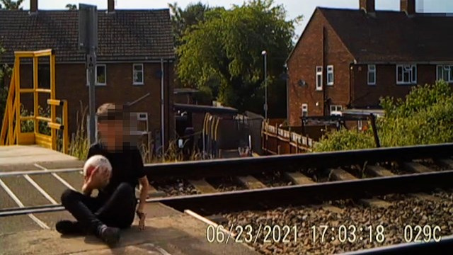 Boy sitting on Jamaica Road level crossing tracks in Malvern