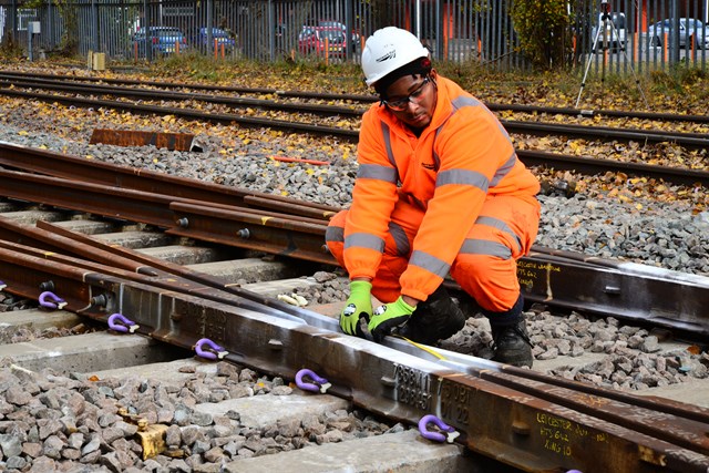 Track worker renewing track crossing in Burton
