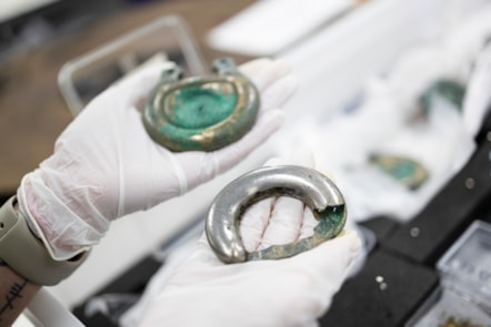 Conservator Bethan Bryan holds bronze fittings. Photo © Duncan McGlynn