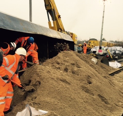 Lewisham sand: Staff shovelling sand out of the derailed wagon