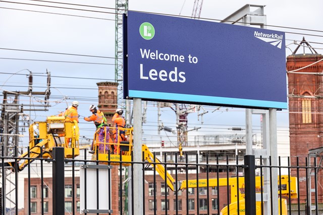 Workers with Leeds station sign