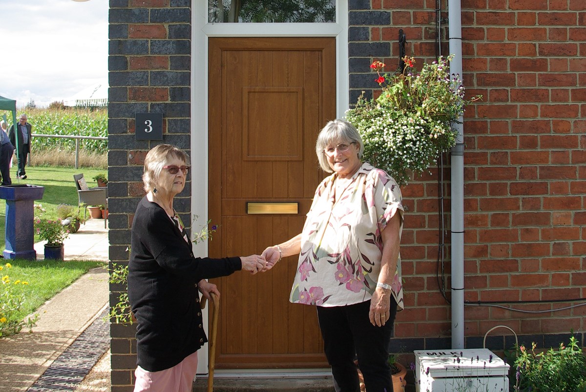 Alison Evans, 4th generation descendant of William Philip Price (left), handing over the keys to Diana Thomas, the new resident of no. 3 (right)