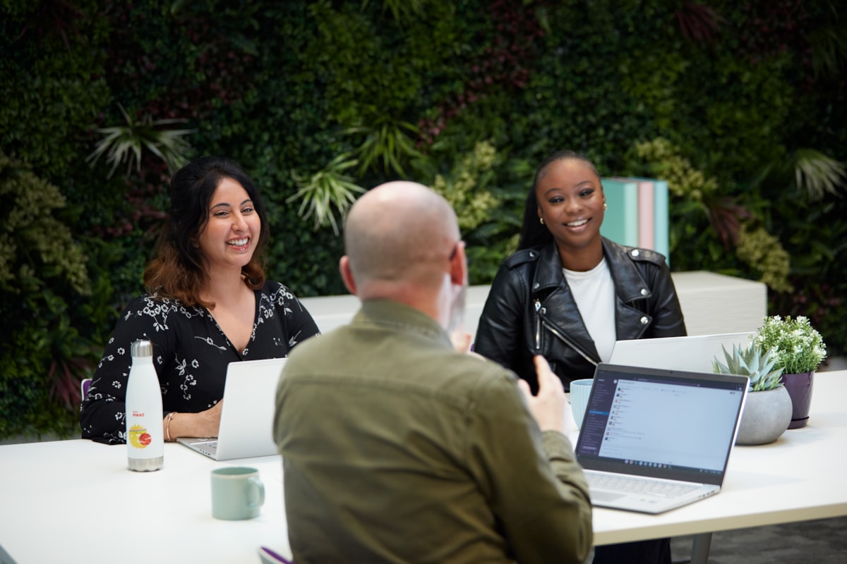 Colleagues at table with green background