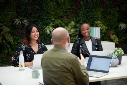 Colleagues at table with green background