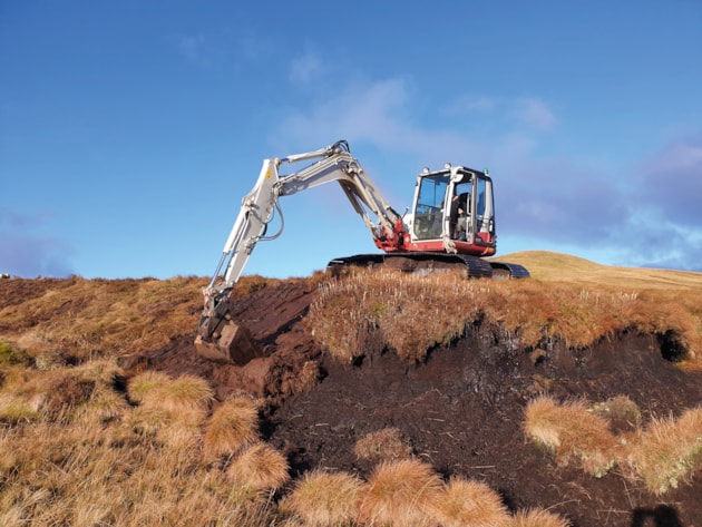 Machine operator re-profiling a bare peat hagg. © R J Cooper/Peatland ACTION LL&TNPA