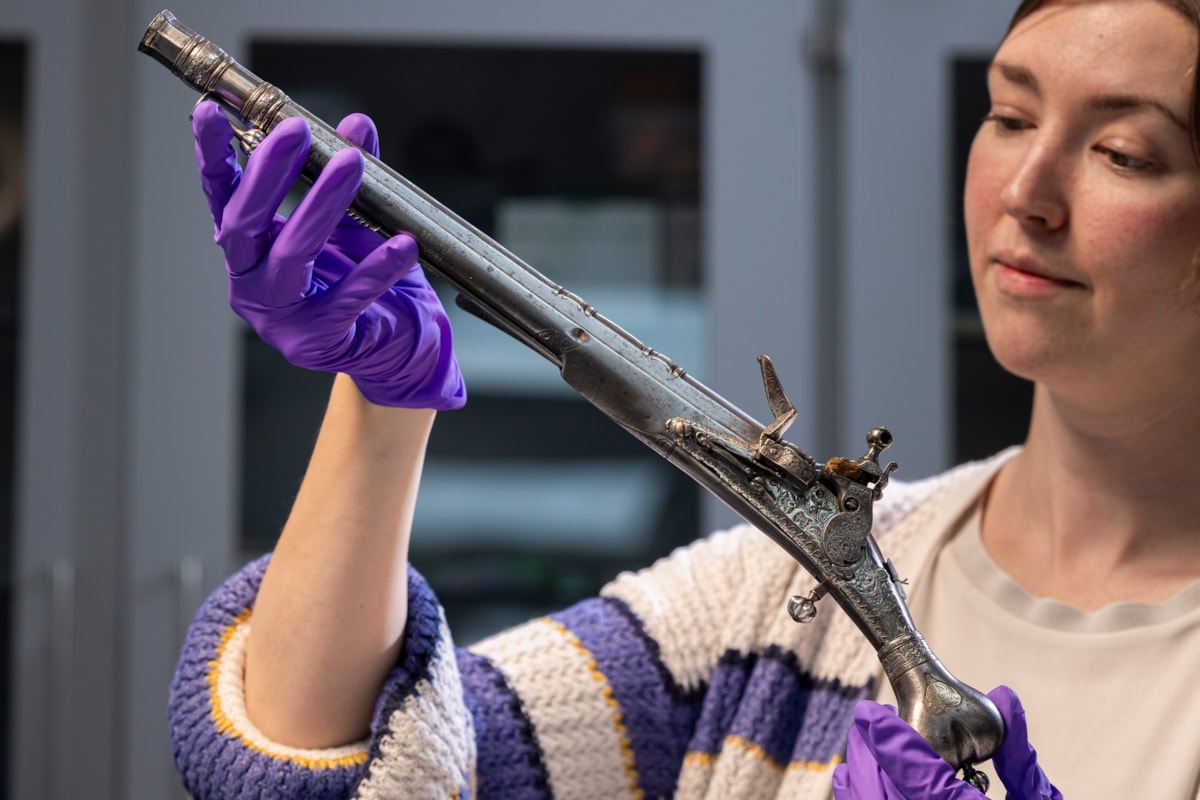 Curator Ella Paul examines the pistol at National Museums Scotland. Image © Duncan McGlynn (1)