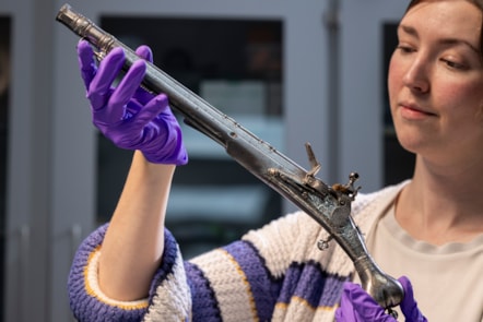 Curator Ella Paul examines the pistol at National Museums Scotland. Image © Duncan McGlynn (1)